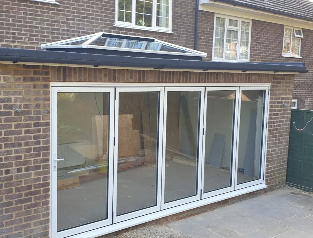 Grey bi-fold doors opening onto a garden room Everglaze Window Solutions Portsmouth