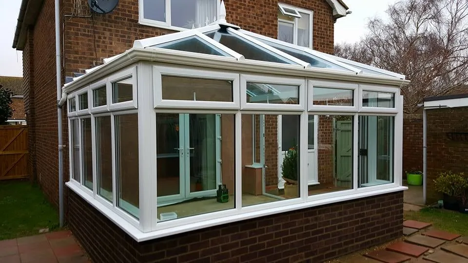 White conservatory overlooking a lawn Everglaze Window Solutions Portsmouth