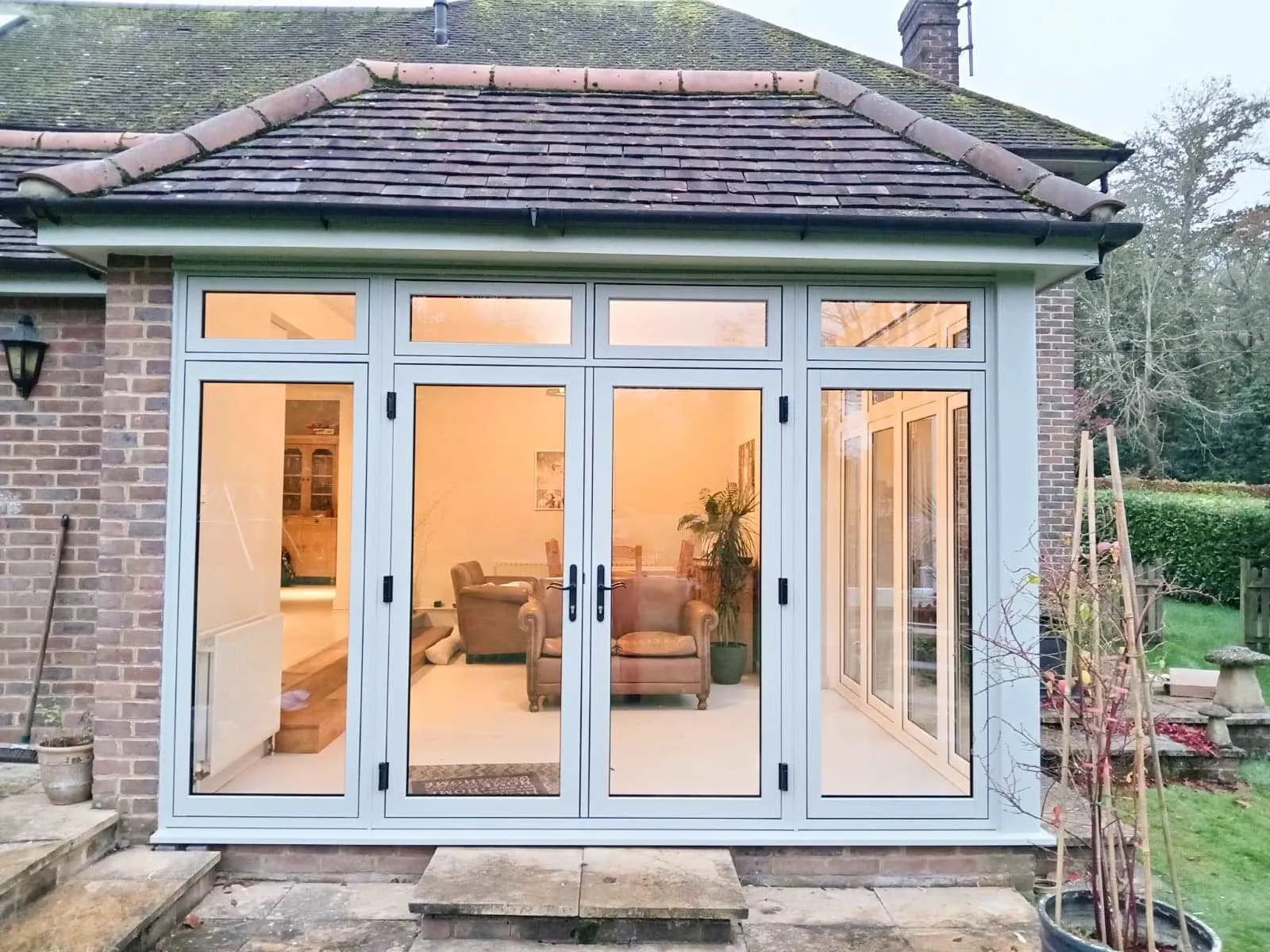 Bi-fold patio doors lit from inside at dusk Everglaze Window Solutions Portsmouth